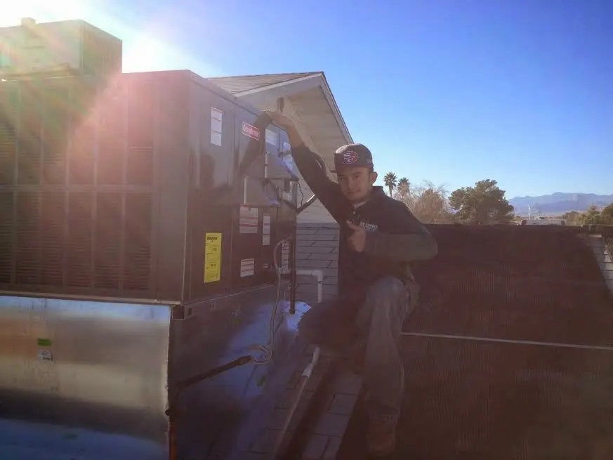 HVAC technician performing AC Tune-Up on a rooftop unit in American Fork